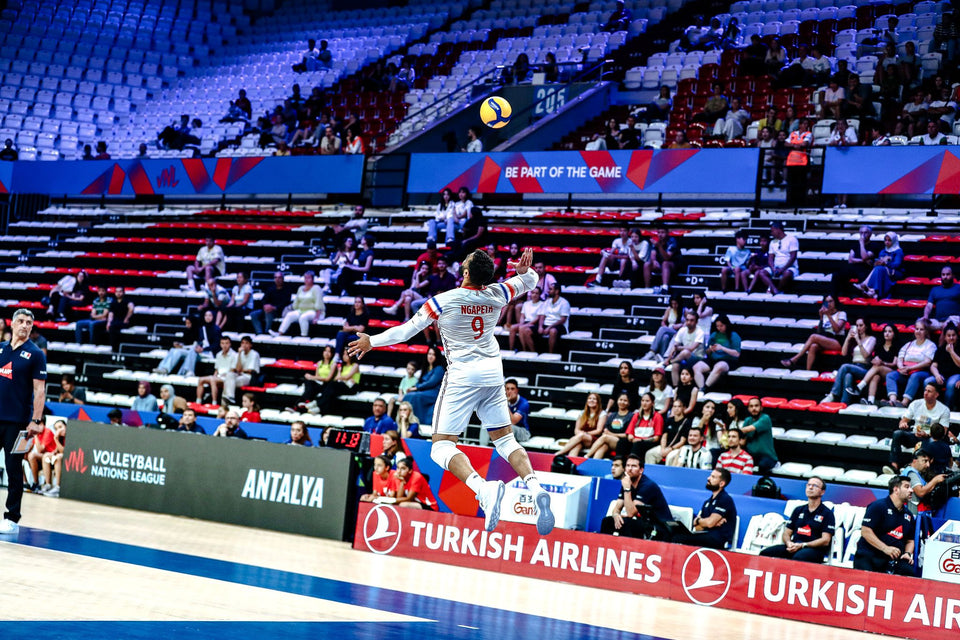 Earvin Ngapeth Joueur sportif en plein match sautant en l’air devant les tribunes